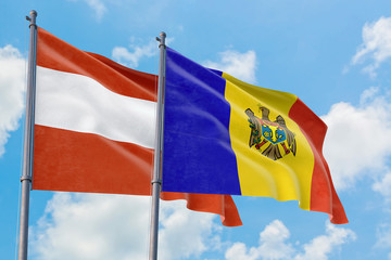 Moldova and Austria flags waving in the wind against white cloudy blue sky together. Diplomacy concept, international relations.