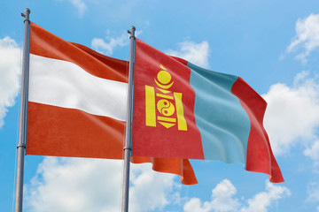 Mongolia and Austria flags waving in the wind against white cloudy blue sky together. Diplomacy concept, international relations.