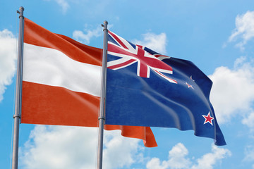 New Zealand and Austria flags waving in the wind against white cloudy blue sky together. Diplomacy concept, international relations.