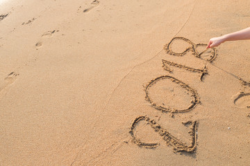 2018 message written in the sand at the beach