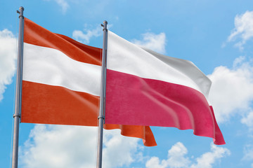 Fototapeta na wymiar Poland and Austria flags waving in the wind against white cloudy blue sky together. Diplomacy concept, international relations.