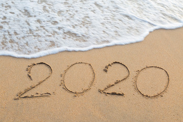 Abstract message Year 2020 written on beach sand