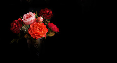 Bouquet of red, pink roses on a black isolated background.Close-up, banner.Flowers for women on holiday.Space for copying and printing.