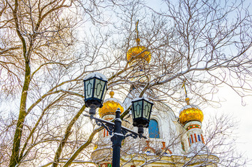 A pole with lanterns near the church.