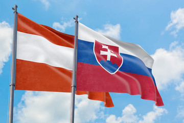 Slovakia and Austria flags waving in the wind against white cloudy blue sky together. Diplomacy concept, international relations.