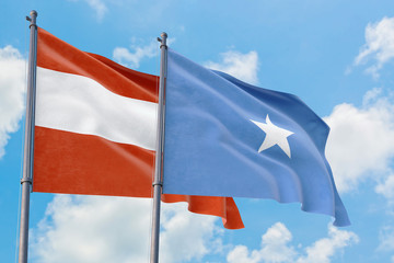 Somalia and Austria flags waving in the wind against white cloudy blue sky together. Diplomacy concept, international relations.