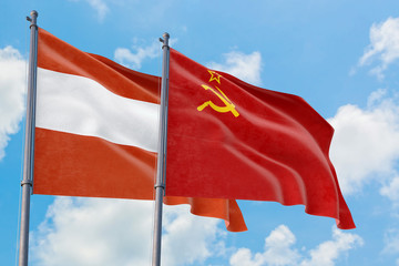 Soviet Union and Austria flags waving in the wind against white cloudy blue sky together. Diplomacy concept, international relations.