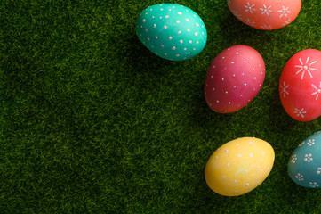 Easter colored eggs on green grass, with space for congratulation. Flat lay