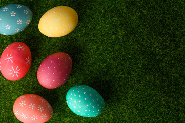 Easter eggs colored on green grass. Congratulations on Easter. Horizontal frame.
