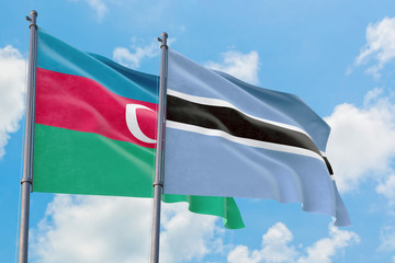 Botswana and Azerbaijan flags waving in the wind against white cloudy blue sky together. Diplomacy concept, international relations.