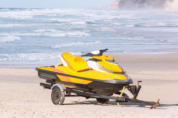 Jet ski on a boat trailer on a sandy beach