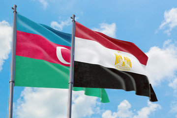 Egypt and Azerbaijan flags waving in the wind against white cloudy blue sky together. Diplomacy concept, international relations.