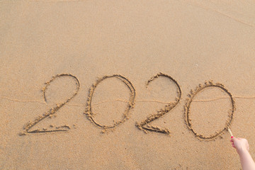 Abstract message Year 2020 written on beach sand
