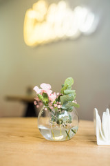 A vase of flowers is located in a cafe on the table.