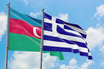 Greece and Azerbaijan flags waving in the wind against white cloudy blue sky together. Diplomacy concept, international relations.