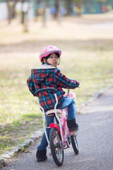 冬の公園で自転車を乗って子供