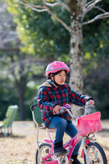 冬の公園で自転車を乗って子供