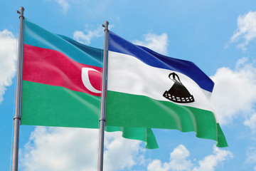 Lesotho and Azerbaijan flags waving in the wind against white cloudy blue sky together. Diplomacy...