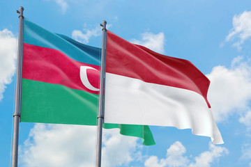 Fototapeta na wymiar Monaco and Azerbaijan flags waving in the wind against white cloudy blue sky together. Diplomacy concept, international relations.