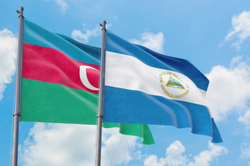 Nicaragua and Azerbaijan flags waving in the wind against white cloudy blue sky together. Diplomacy concept, international relations.