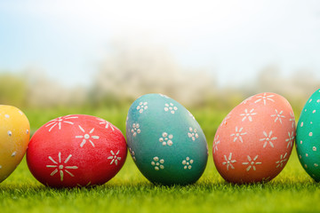 Easter banner, Easter colored eggs with drawings on the green grass in the spring garden, Easter celebration.
