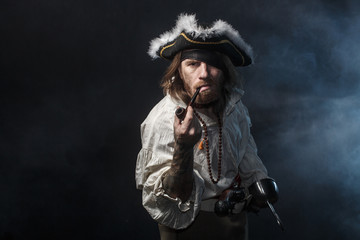 medieval bearded pirate with a sword and gun. concept photo of handsome man in a pirate vintage costume with pistol and saber - 320455457