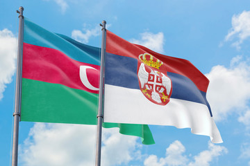 Serbia and Azerbaijan flags waving in the wind against white cloudy blue sky together. Diplomacy concept, international relations.