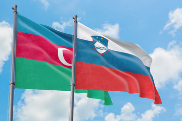 Slovenia and Azerbaijan flags waving in the wind against white cloudy blue sky together. Diplomacy concept, international relations.