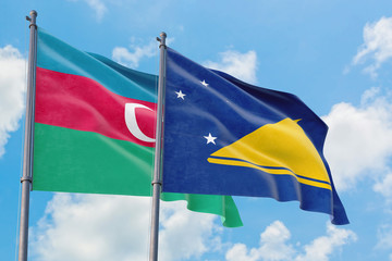 Tokelau and Azerbaijan flags waving in the wind against white cloudy blue sky together. Diplomacy concept, international relations.