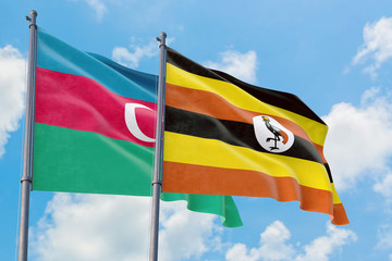 Uganda and Azerbaijan flags waving in the wind against white cloudy blue sky together. Diplomacy concept, international relations.