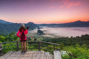 Young gril in red jacket hiking on Phu- lang-ka, Payao province, Thailand.