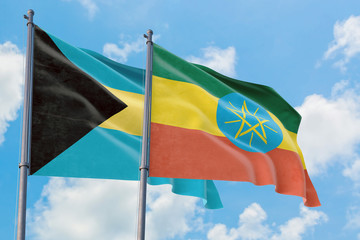 Ethiopia and Bahamas flags waving in the wind against white cloudy blue sky together. Diplomacy concept, international relations.