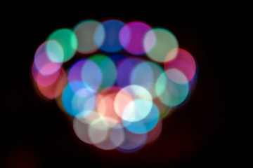Spiral swirl of colorful bokeh lights at night with a black background