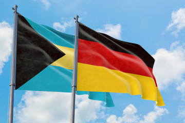 Germany and Bahamas flags waving in the wind against white cloudy blue sky together. Diplomacy concept, international relations.