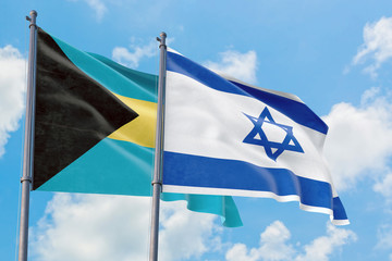 Israel and Bahamas flags waving in the wind against white cloudy blue sky together. Diplomacy concept, international relations.