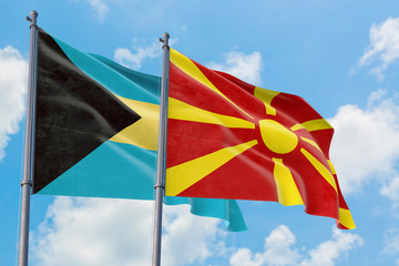 Macedonia and Bahamas flags waving in the wind against white cloudy blue sky together. Diplomacy concept, international relations.