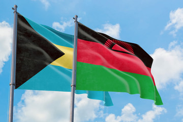 Malawi and Bahamas flags waving in the wind against white cloudy blue sky together. Diplomacy concept, international relations.