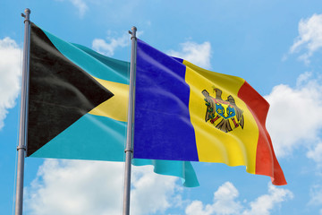Moldova and Bahamas flags waving in the wind against white cloudy blue sky together. Diplomacy concept, international relations.