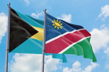 Namibia and Bahamas flags waving in the wind against white cloudy blue sky together. Diplomacy concept, international relations.