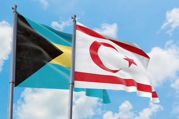 Northern Cyprus and Bahamas flags waving in the wind against white cloudy blue sky together. Diplomacy concept, international relations.