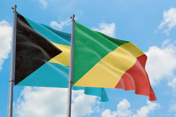 Republic Of The Congo and Bahamas flags waving in the wind against white cloudy blue sky together. Diplomacy concept, international relations.