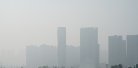 Air pollution in the city with skyscraper buildings in the haze