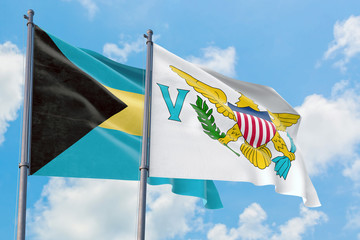 United States Virgin Islands and Bahamas flags waving in the wind against white cloudy blue sky together. Diplomacy concept, international relations.