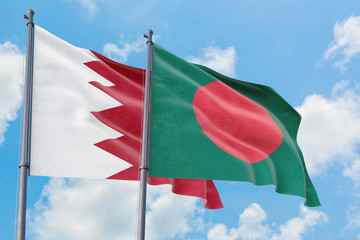Bangladesh and Bahrain flags waving in the wind against white cloudy blue sky together. Diplomacy concept, international relations.