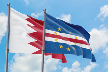 Cape Verde and Bahrain flags waving in the wind against white cloudy blue sky together. Diplomacy concept, international relations.