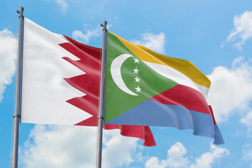 Comoros and Bahrain flags waving in the wind against white cloudy blue sky together. Diplomacy concept, international relations.