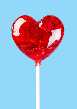 Shiny red lollipop in the shape of a heart for Valentine's day.
