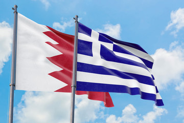Greece and Bahrain flags waving in the wind against white cloudy blue sky together. Diplomacy concept, international relations.