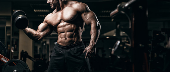 Muskulöser Bodybuilder trainiert im Fitnessstudio und posiert. Fit Muskeltraining mit Gewichten und Langhantel