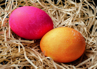 Pink and orange Easter eggs in a nest